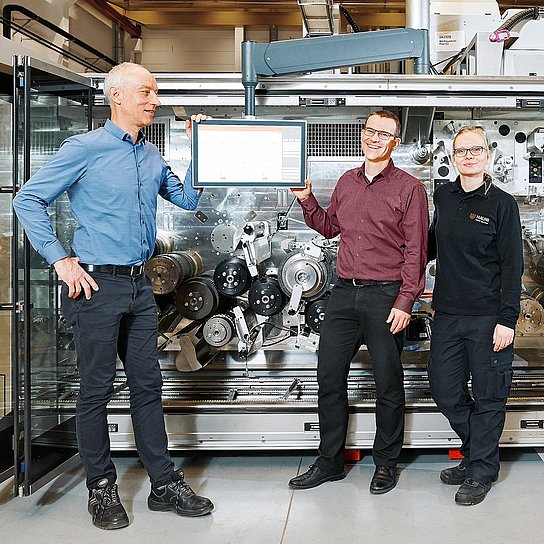 Foto der Hauni-Mitarbeiter Karsten Barsch, Christian Junge und Nina Gröncke vor einer Maschine, dem Multi-Segment-Maker